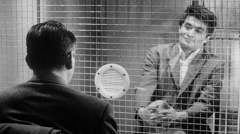 Ginjirō Takeuchi assis derrière le mur de la prison dans High and Low