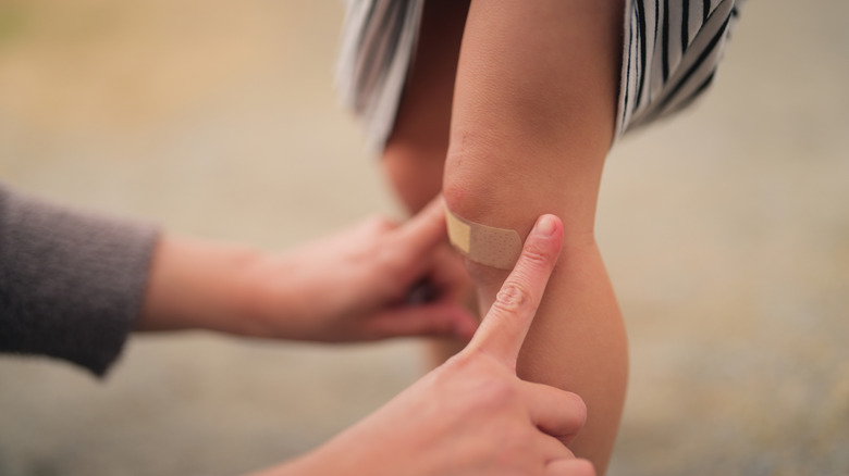 Une personne appliquant un pansement sur un genou