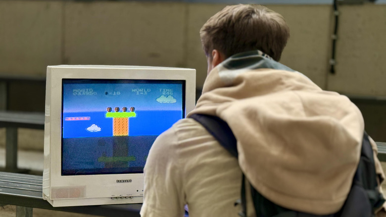 Un jeune homme jouant à Super Mario Bros. sur un téléviseur CRT.
