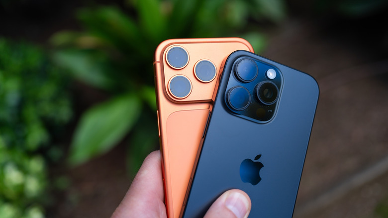 Une personne tenant quelques iPhones