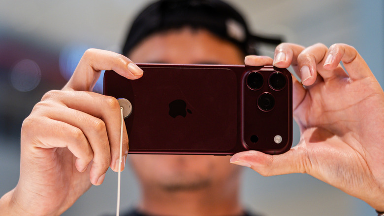 Une personne tenant un iPhone 18 Pro pour prendre une photo.