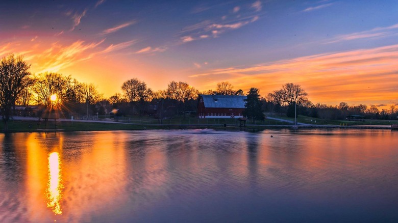 grange historique et étang au coucher du soleil dans le parc Crites