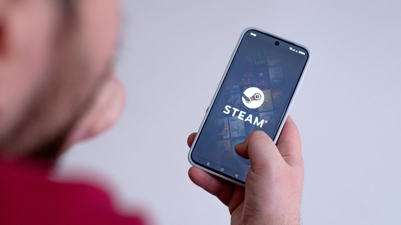 Une personne chargeant l’application Steam sur un smartphone.