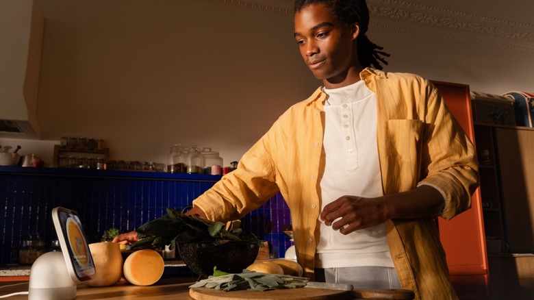L'homme suit une recette dans la cuisine sur un appareil Apple HomeView.