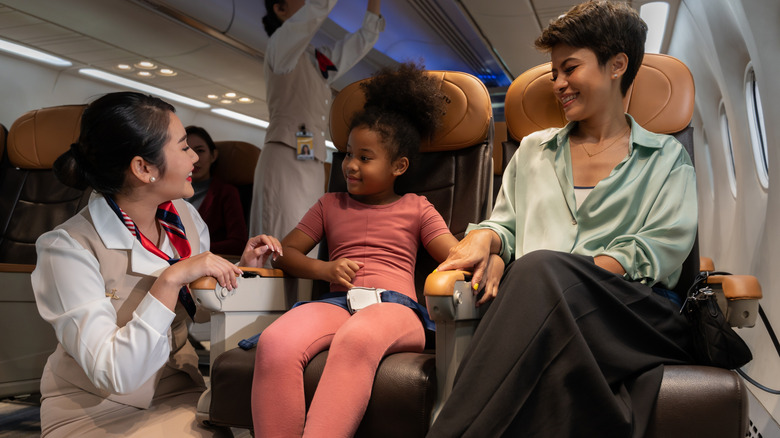 heureux agent de bord parlant à une femme et un enfant