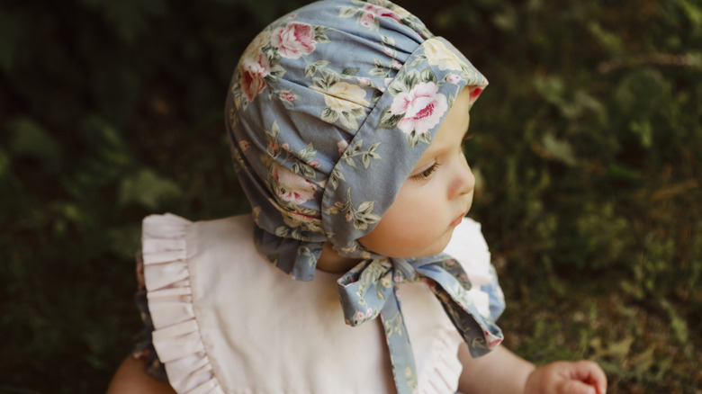 Une petite fille portant un bonnet et un bavoir