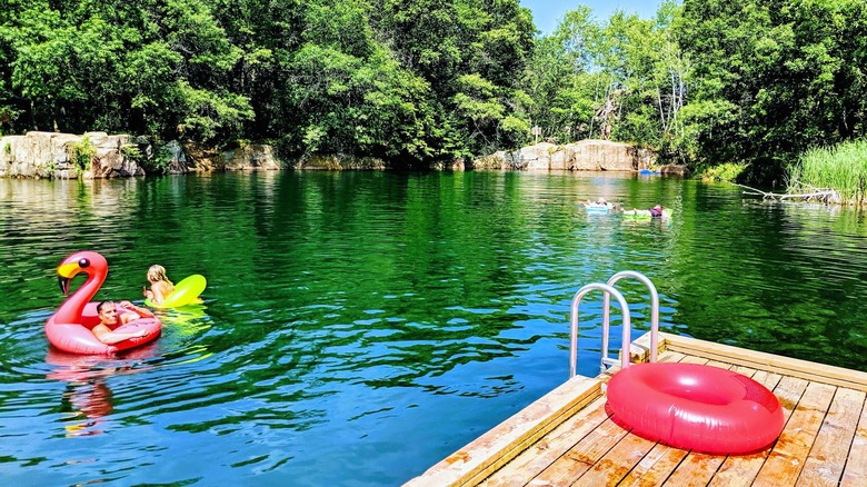 nageurs dans des flotteurs colorés près d'un quai dans l'une des carrières de natation du Quarry Park & ​​Nature Preserve
