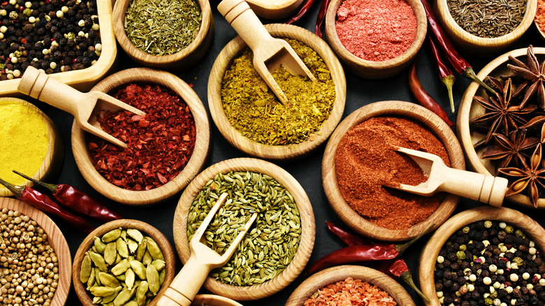 Assortiment d'épices et d'herbes dans des bols en bois sur table