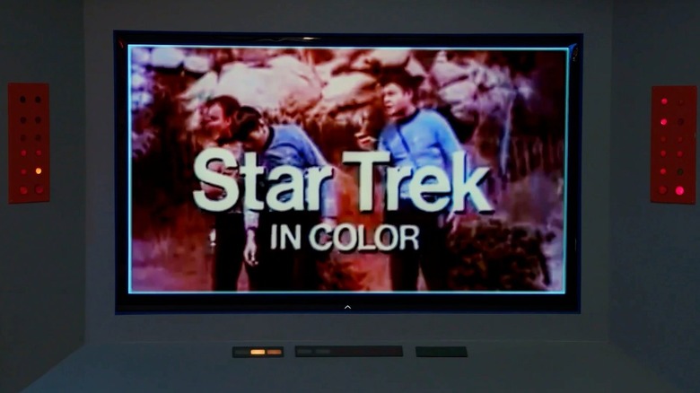 Image d'un écran de télévision représentant William Shatner dans le rôle de James Kirk, debout à côté de Leonard Nimoy dans le rôle de Spock et DeForest Kelley dans le rôle de Bones, tiré d'un épisode de Star Trek : la série originale dans La mission de soixante ans : comment Star Trek a changé la télévision et le monde.