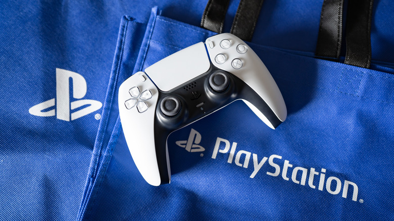 Une manette DualSense sur une pile de sacs PlayStation.