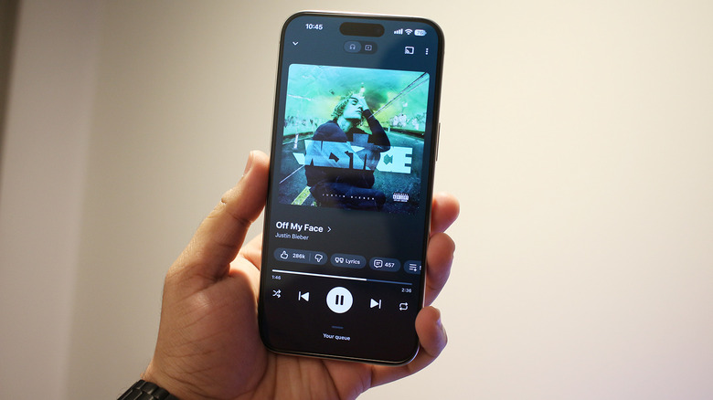 Main tenant un iPhone avec Spotify à l'écran