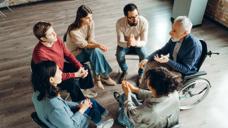 Un groupe de personnes assises en cercle et discutant