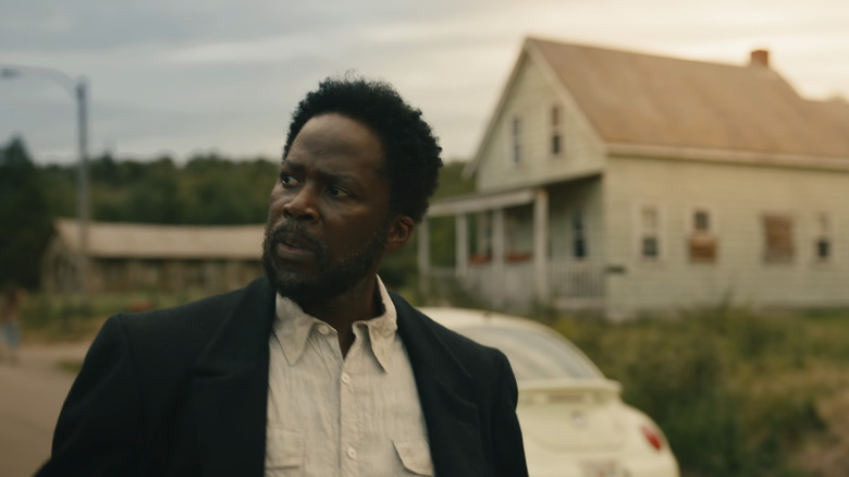 Boyd Stevens d'Harold Perrineau regarde à sa droite alors qu'il passe devant une maison à partir de