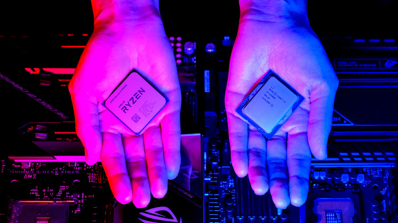 Deux mains, l'une tenant un processeur AMD Ryzen et l'autre un processeur Intel Core Series