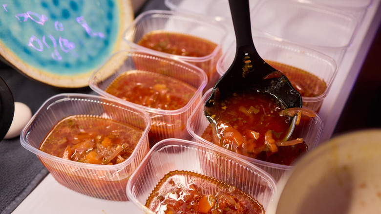 Soupe étant portionnée dans de petits récipients en plastique