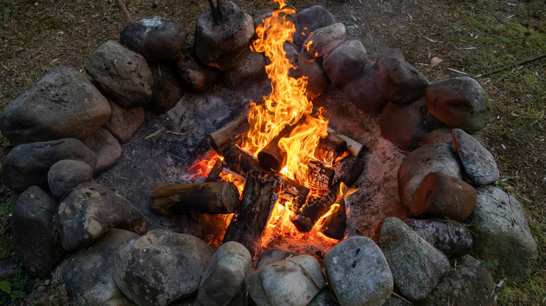 Feu de camp brûlant à l'intérieur d'un anneau de pierre