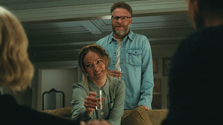 Angela lève un verre pour porter un toast à Hawk et Pina avec Joe derrière elle dans The Invite