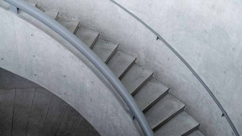 Un escalier en béton moderne et incurvé dans des tons monochromes de gris