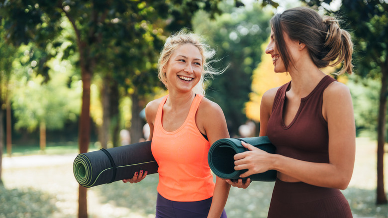 Deux femmes portant des tapis de yoga