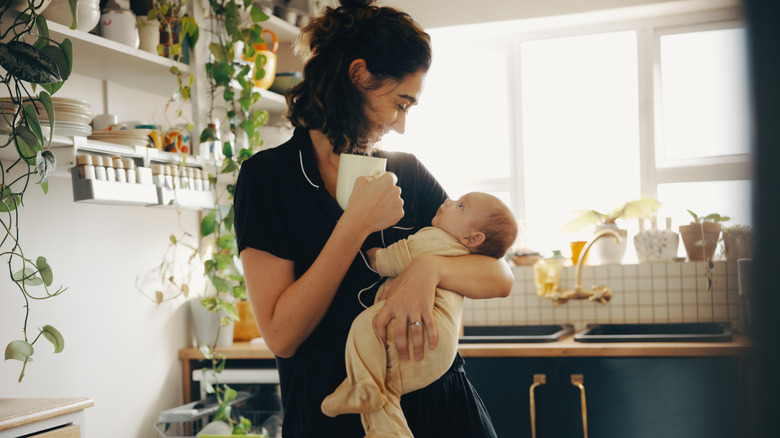 Une mère tenant son bébé dans la cuisine