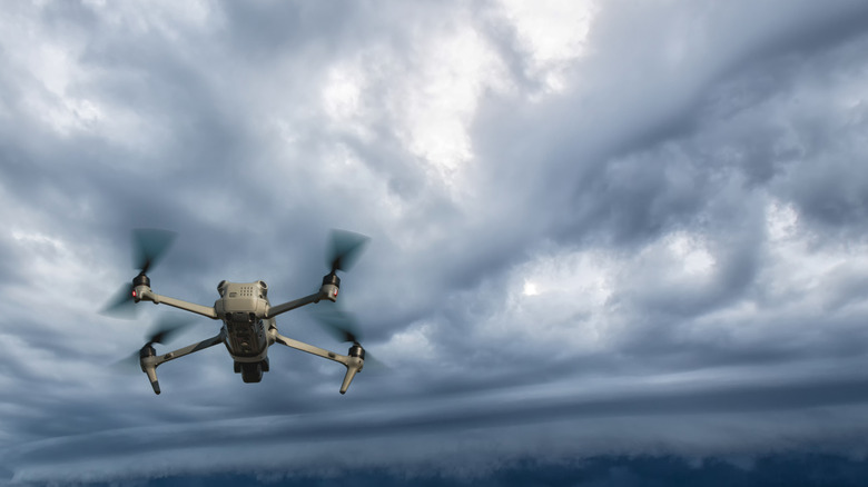 Un drone quadricoptère vole près des nuages ​​de pluie