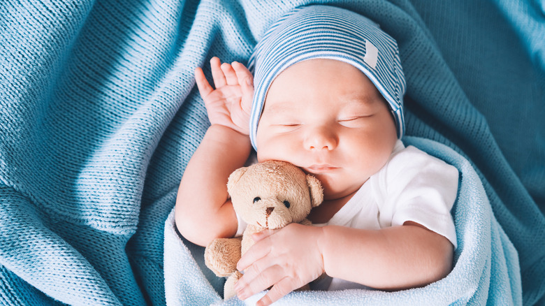 Un petit garçon qui dort paisiblement tout en tenant une peluche