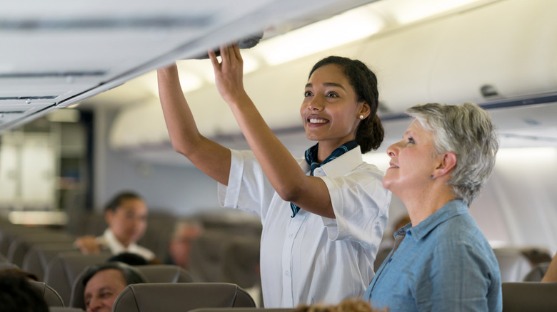 agent de bord aidant un passager