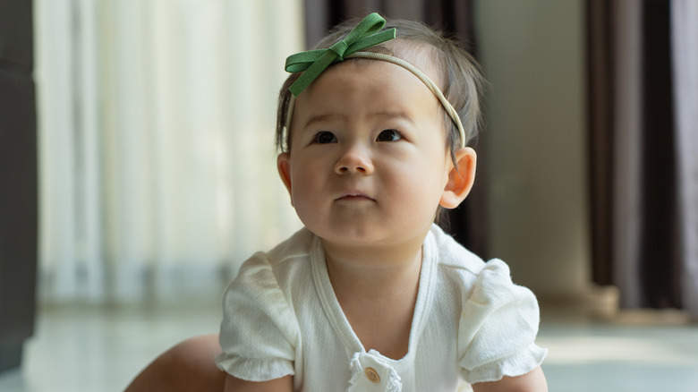 Bébé avec un bandeau vert