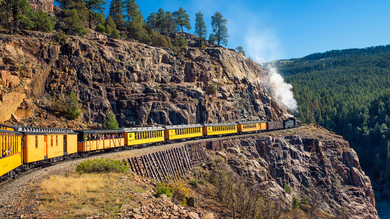 Train jaune historique traversant les montagnes de San Juan du Colorado entre Durango et Silverton au-dessus d'une gorge escarpée