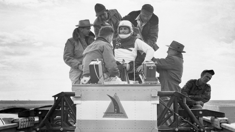 Le colonel John Stapp, portant un casque blanc, attaché à un traîneau-fusée