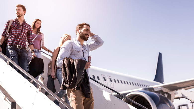 Passagers quittant un avion par l'escalier