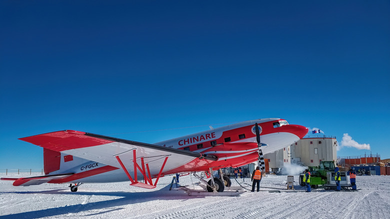 Avion rouge et blanc stationné sur la glace au Dôme C en Antarctique