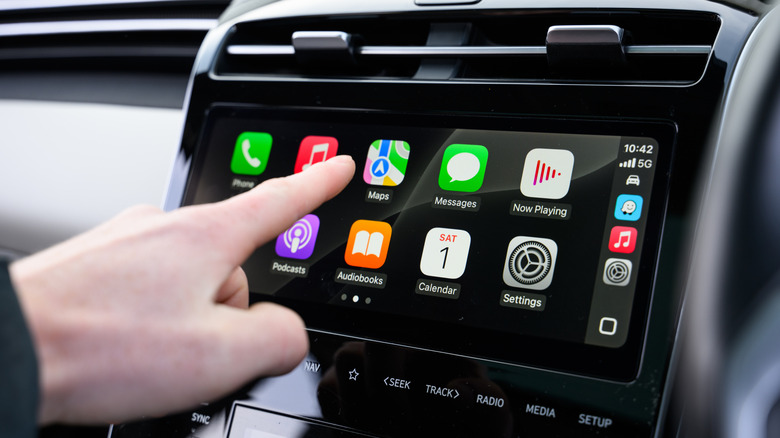 Une personne utilisant Apple CarPlay sur le système d'infodivertissement