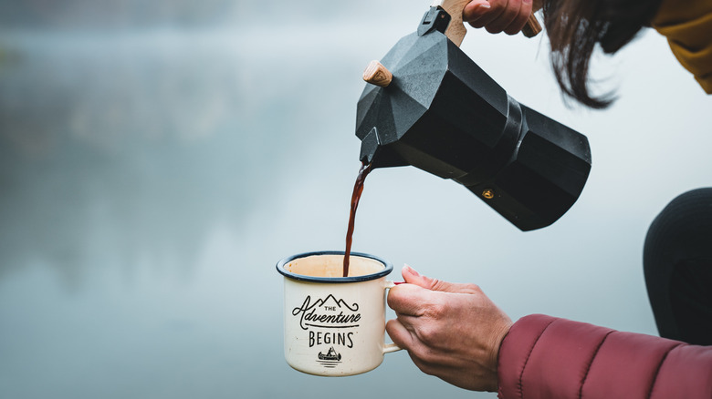 Une personne versant du café à l’extérieur