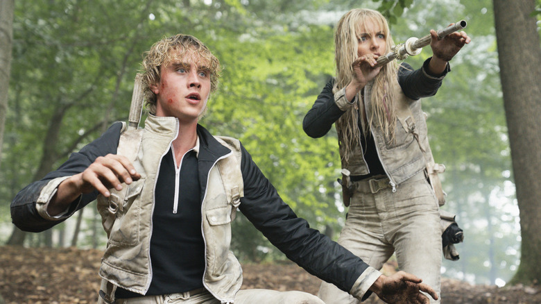 Haymitch a l'air choqué et Maysilee vise une fléchette empoisonnée dans The Hunger Games : Sunrise on the Reaping