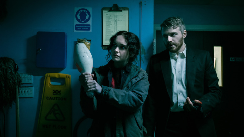 Olivia Cooke dans le rôle de Sid Baker brandissant une quille de bowling comme arme à côté de Jack Lowden dans le rôle de River Cartwright dans Slow Horses